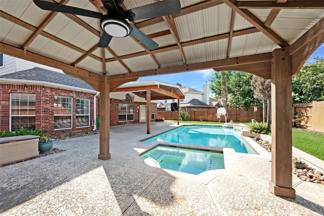 view of pool with a patio, a fenced backyard, a pool with connected hot tub, a ceiling fan, and a gazebo