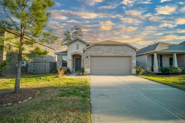 view of front of property with concrete driveway, a lawn, and an attached garage