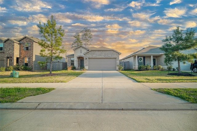 view of front of house featuring concrete driveway, a front lawn, an attached garage, and fence