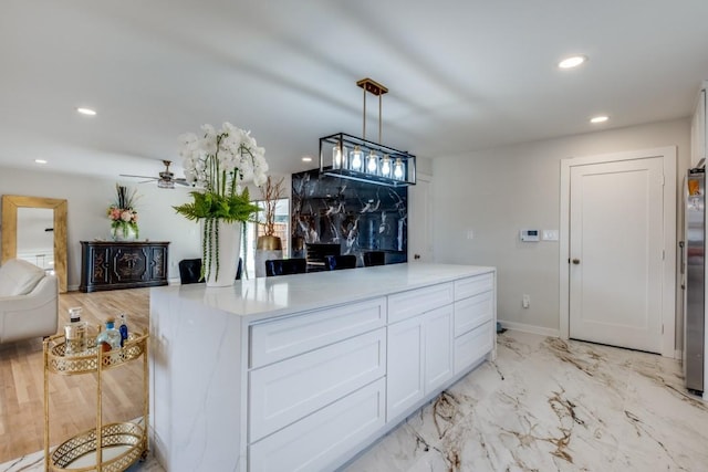 kitchen featuring marble finish floor, recessed lighting, light countertops, and white cabinets