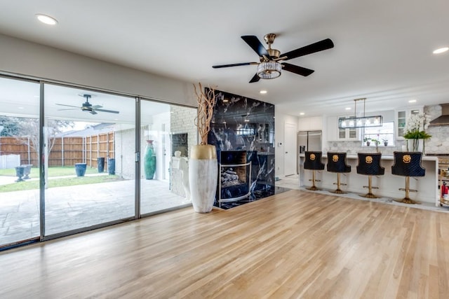 unfurnished living room featuring light wood finished floors, ceiling fan, and recessed lighting