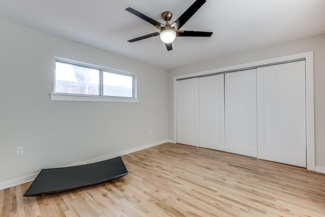 unfurnished bedroom with light wood-style floors, a closet, ceiling fan, and baseboards