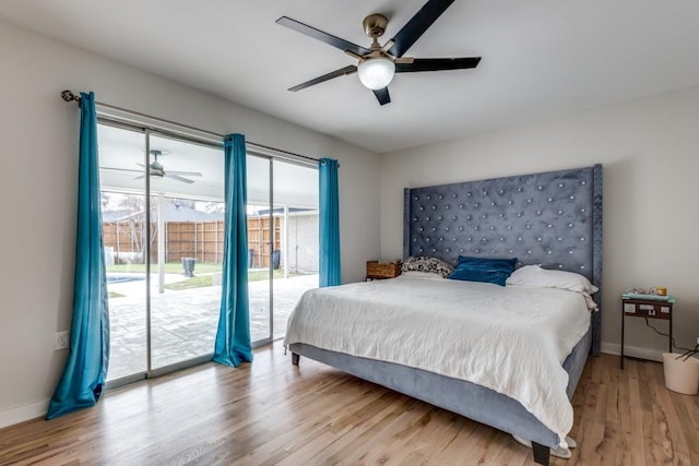 bedroom featuring access to exterior, a ceiling fan, baseboards, and wood finished floors