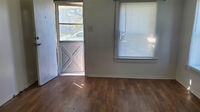 doorway featuring baseboards and wood finished floors