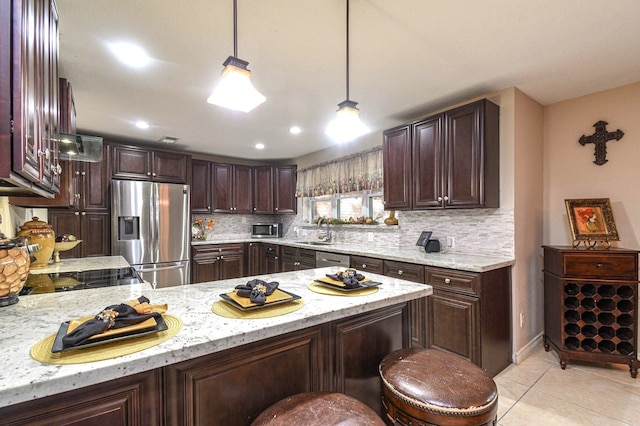 kitchen with stainless steel appliances, light tile patterned flooring, a sink, dark brown cabinets, and a peninsula