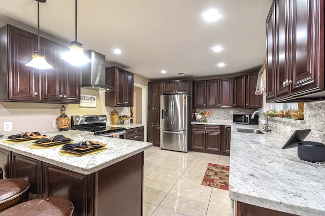 kitchen with dark brown cabinetry, wall chimney exhaust hood, a peninsula, stainless steel appliances, and a sink