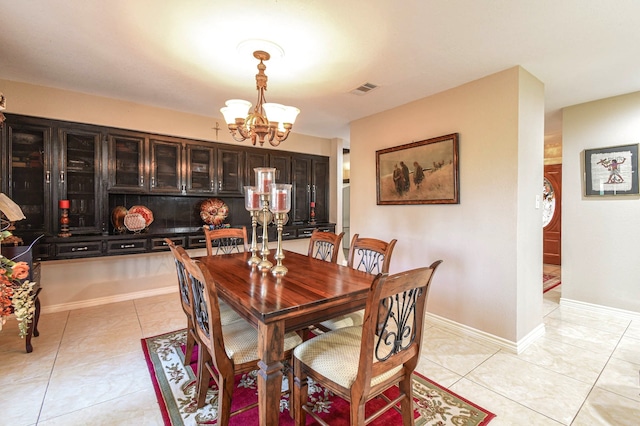 dining space featuring baseboards, visible vents, an inviting chandelier, and light tile patterned floors