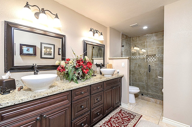 bathroom featuring a stall shower, tile patterned flooring, visible vents, and a sink