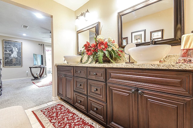 full bathroom featuring double vanity, visible vents, ornamental molding, tile patterned flooring, and baseboards