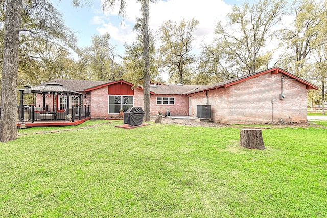 back of property with a gazebo, a yard, brick siding, and central air condition unit