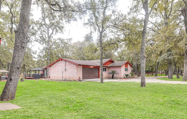 view of property exterior with driveway, a yard, and brick siding