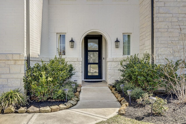 doorway to property featuring brick siding