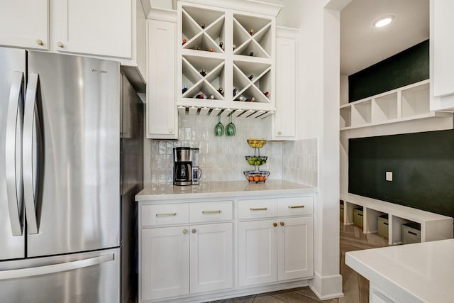 kitchen featuring white cabinetry, light countertops, freestanding refrigerator, and open shelves