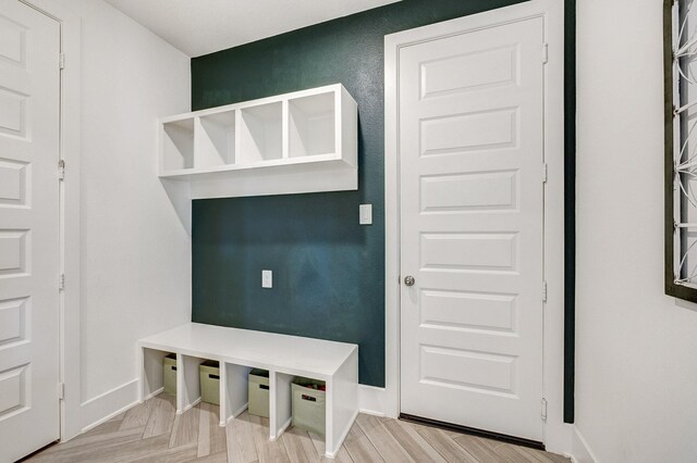 mudroom featuring parquet flooring and baseboards