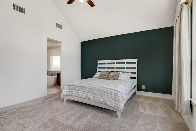 carpeted bedroom featuring ceiling fan, ensuite bath, visible vents, and high vaulted ceiling