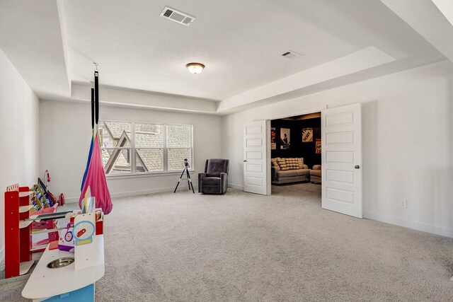 rec room featuring visible vents, baseboards, carpet, and a tray ceiling