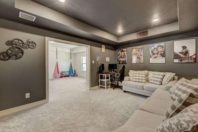 carpeted cinema room featuring visible vents, recessed lighting, baseboards, and a tray ceiling