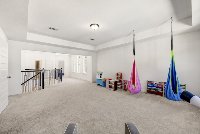 playroom featuring a tray ceiling, visible vents, and carpet floors