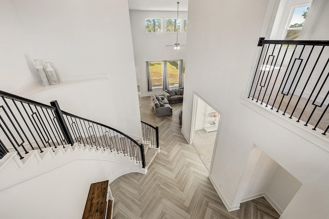 stairs featuring baseboards and a towering ceiling