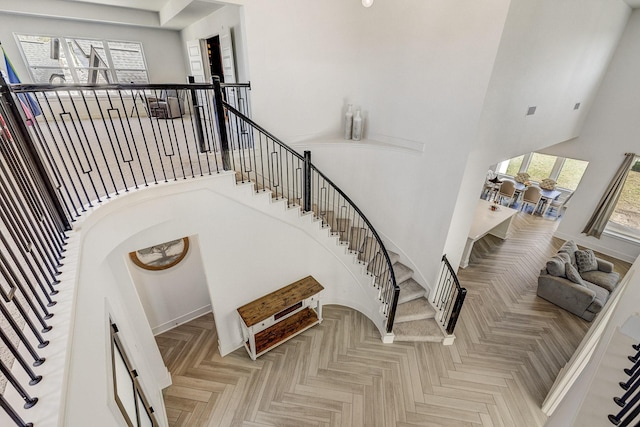 stairway featuring a towering ceiling