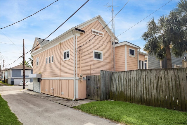 view of side of property with a lawn and fence