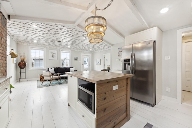 kitchen featuring butcher block counters, white cabinets, light wood finished floors, and stainless steel appliances