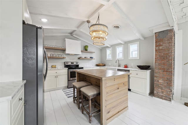 kitchen featuring visible vents, wooden counters, open shelves, stainless steel appliances, and a sink