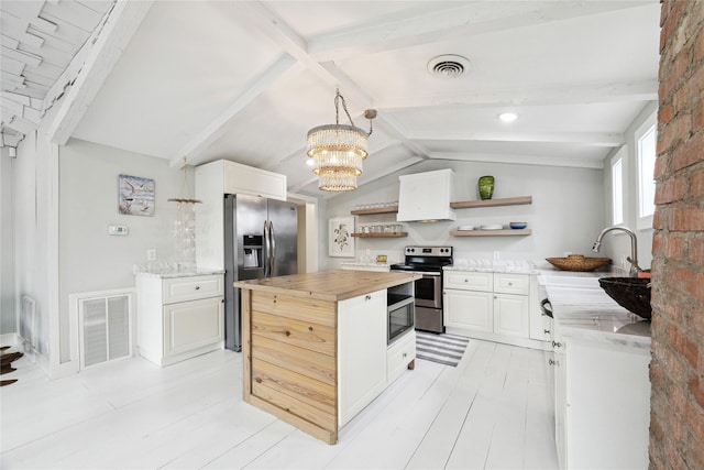 kitchen with open shelves, stainless steel appliances, visible vents, and butcher block counters