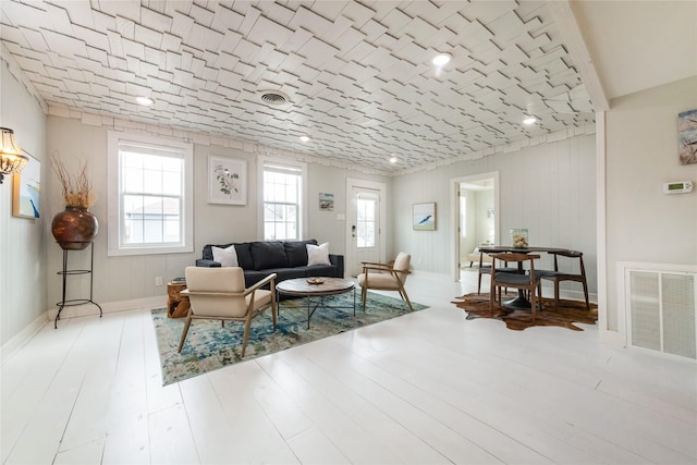 living area with visible vents, baseboards, and wood finished floors