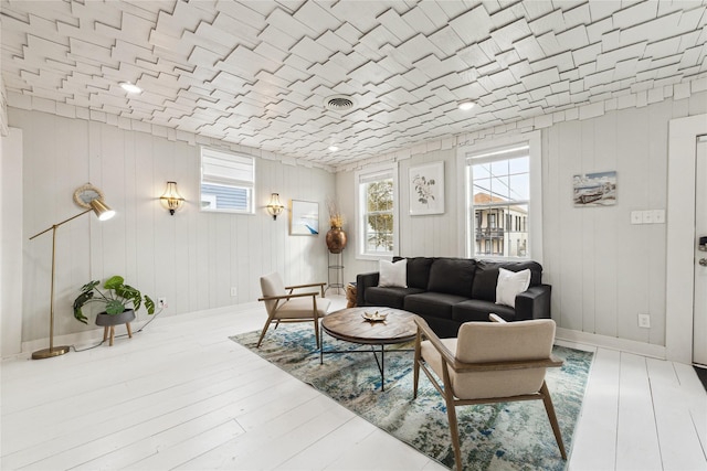 living area with visible vents, baseboards, and wood finished floors