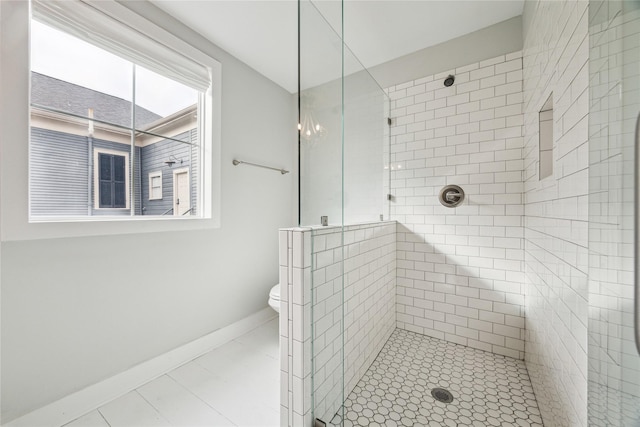 full bath featuring a stall shower, toilet, and baseboards