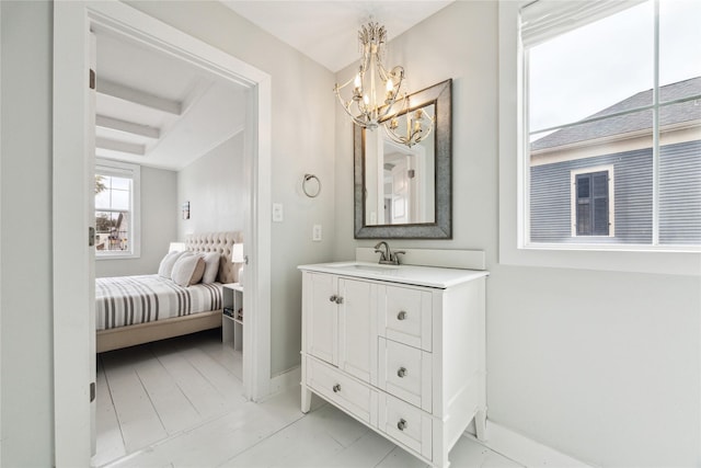 bathroom with vanity, baseboards, and a chandelier