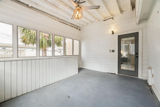 unfurnished sunroom with beam ceiling