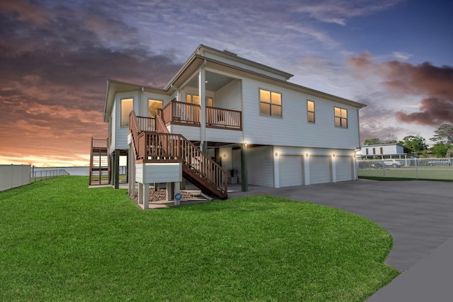 view of front of property with driveway, stairway, an attached garage, fence, and a front lawn