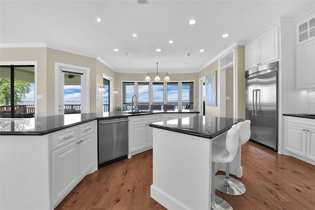 438 S Burnett Dr, Baytown, TX 77520 - kitchen with dark wood-style flooring, appliances with stainless steel finishes, white cabinetry, a kitchen island, and a sink