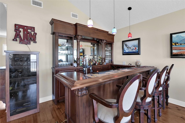 438 S Burnett Dr, Baytown, TX 77520 - bar with indoor wet bar, visible vents, vaulted ceiling, and dark wood-style floors