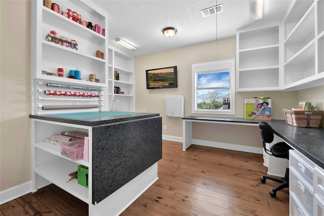 438 S Burnett Dr, Baytown, TX 77520 - home office with dark wood-style floors, visible vents, a textured ceiling, and baseboards