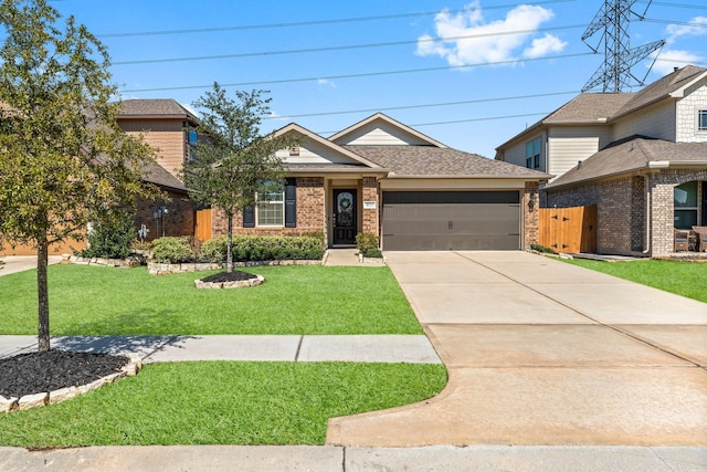 view of front of house with driveway, roof with shingles, an attached garage, a front lawn, and brick siding