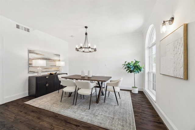 dining room featuring baseboards, dark wood-style flooring, visible vents, and an inviting chandelier