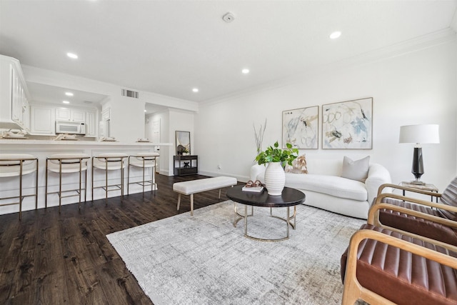 living area with dark wood-style floors, visible vents, crown molding, and recessed lighting