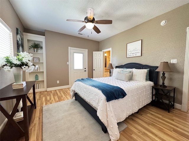 bedroom featuring visible vents, light wood-type flooring, baseboards, and ceiling fan
