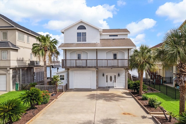 438 Jeanie Lynne Cir, Galveston, TX 77554 - view of front facade with an attached garage, a balcony, driveway, and a shingled roof