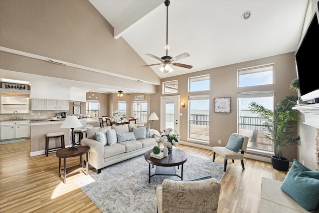 438 Jeanie Lynne Cir, Galveston, TX 77554 - living room featuring high vaulted ceiling, light wood-type flooring, beam ceiling, ceiling fan, and healthy amount of natural light