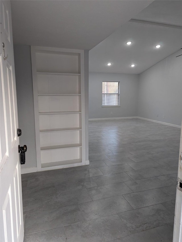 empty room featuring baseboards, built in features, and recessed lighting