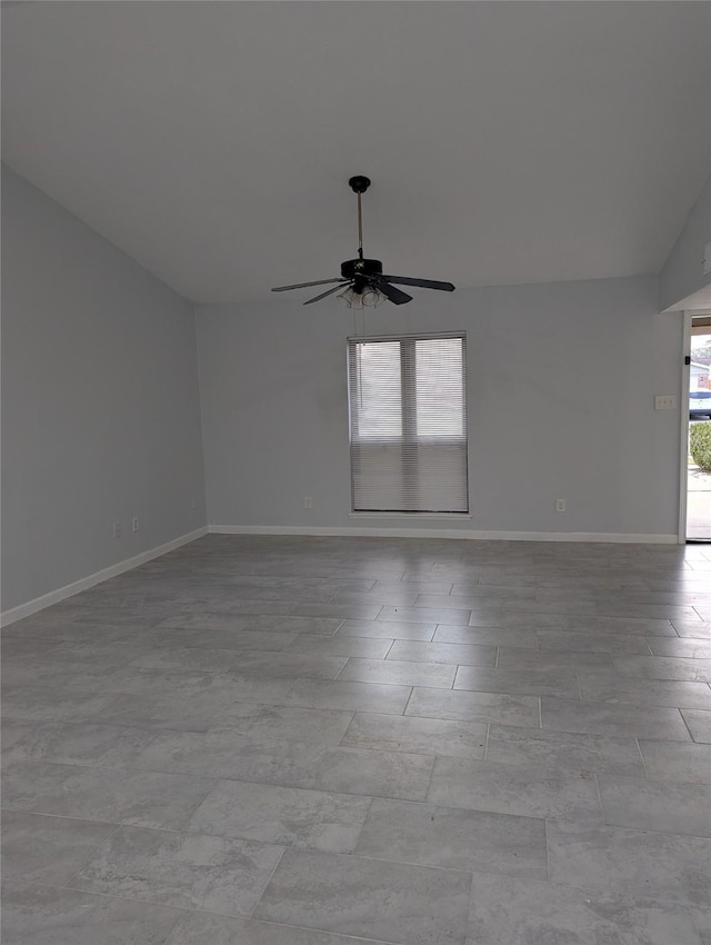 unfurnished room with ceiling fan, lofted ceiling, and baseboards