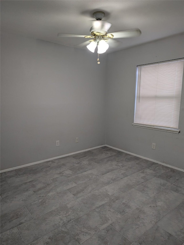 empty room featuring baseboards and a ceiling fan