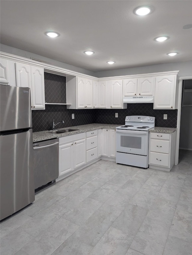 kitchen with light stone countertops, under cabinet range hood, appliances with stainless steel finishes, and a sink