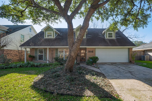 new england style home with a front yard, concrete driveway, brick siding, and central air condition unit