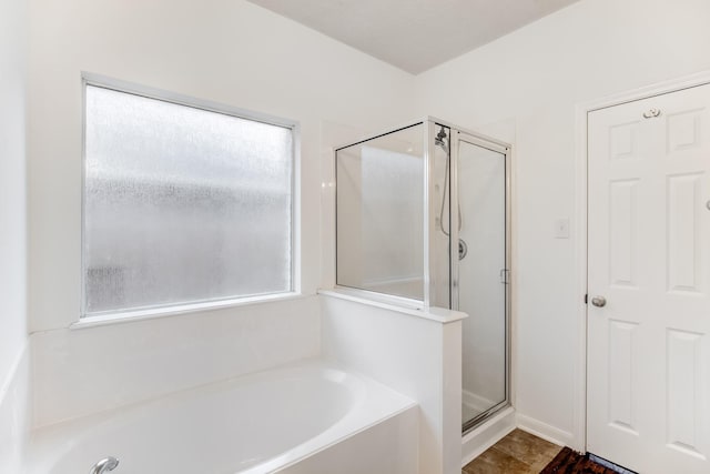 bathroom with a stall shower and a garden tub