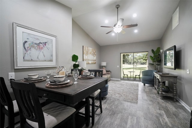 dining area with high vaulted ceiling, a ceiling fan, baseboards, and wood finished floors